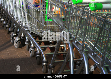 Carrello per lo shopping, inventato, 1937 Oklahoma, supermercato, Carrello per lo shopping, ASDA, immagazzinato, allineato-su, raccolto, guidato, linee, serpente, snaked, di fronte, parcheggio. Foto Stock