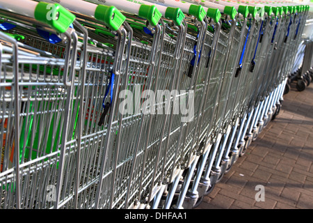 Carrello per lo shopping, inventato, 1937 Oklahoma, supermercato, Carrello per lo shopping, ASDA, immagazzinato, allineato-su, raccolto, guidato, linee, serpente, snaked, di fronte, parcheggio. Foto Stock