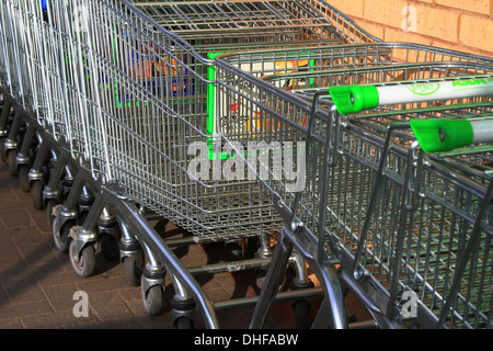 Carrello per lo shopping, inventato, 1937 Oklahoma, supermercato, Carrello per lo shopping, ASDA, immagazzinato, allineato-su, raccolto, guidato, linee, serpente, snaked, di fronte, parcheggio. Foto Stock