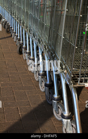 Carrello per lo shopping, inventato, 1937 Oklahoma, supermercato, Carrello per lo shopping, ASDA, immagazzinato, allineato-su, raccolto, guidato, linee, serpente, snaked, di fronte, parcheggio. Foto Stock