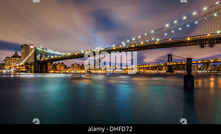 Ponte di Brooklyn Bridge spanning l'East River all'alba Foto Stock