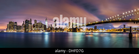 La parte inferiore di Manhattan e il Ponte di Brooklyn sotto un cielo nuvoloso al mattino come vista dal Ponte di Brooklyn Park. Foto Stock