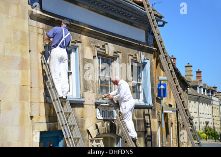 Pittori lavorando su scale, St George Square, Stamford, Lincolnshire, England, Regno Unito Foto Stock