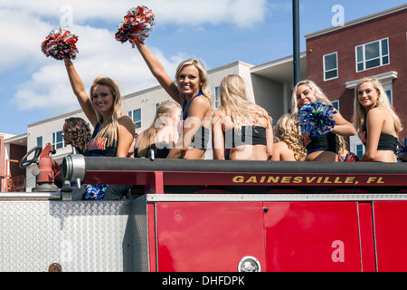 Florida cheer leader squadra a cavallo su camion dei pompieri in università di Florida Homecoming Parade 2013 a Gainesville, Florida. Stati Uniti d'America Foto Stock