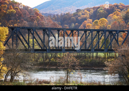 Stazione ponte sul fiume, tra due colline, con fogliame di autunno Foto Stock