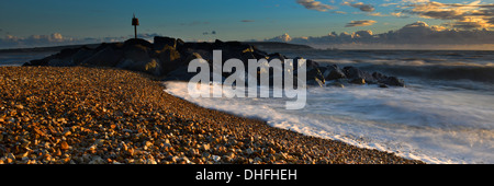 Le onde di colpire la spiaggia su Hurst allo spiedo, Milford-on-Sea, Hampshire al tramonto Foto Stock