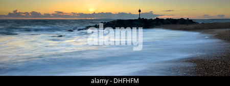 Le onde di colpire la spiaggia su Hurst allo spiedo, Milford-on-Sea, Hampshire al tramonto Foto Stock