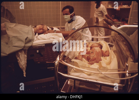 L'immagine mostra una donna che ha appena partorito nella sala parto dell'ospedale Loretto di New Ulm, Minnesota. Il momento cattura la gioia del parto e la presenza di sostegno familiare durante il processo. Foto Stock