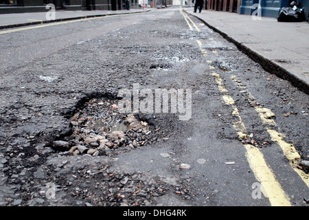 Buca strada danneggiata su London Road street REGNO UNITO Foto Stock