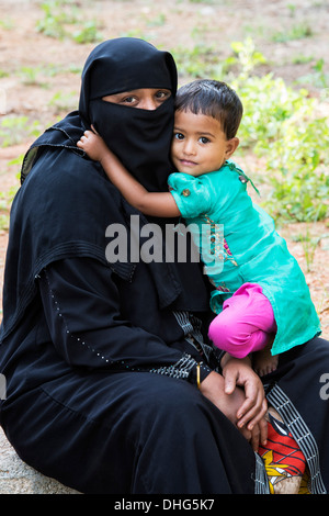 Musulmani indiani ragazza infantile abbracci la madre. Andhra Pradesh, India Foto Stock