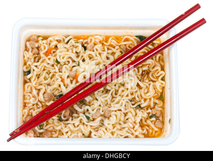 Vista superiore del cotto spaghetti istantanei e bacchette rosso nel tappo in schiuma isolati su sfondo bianco Foto Stock