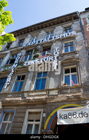 Squat in Prenzlauer Berg con anti-capitalista messaggio sulla parte anteriore dell'edificio di Berlino Germania Foto Stock