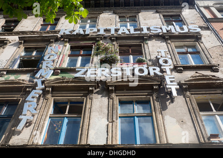 Squat in Prenzlauer Berg con anti-capitalista messaggio sulla parte anteriore dell'edificio di Berlino Germania Foto Stock