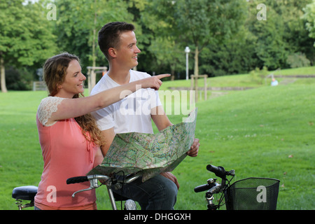 Una giovane coppia fa una breve pausa durante un tour in bicicletta Foto Stock