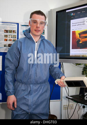 Dundee, Scotland, Regno Unito. 9 Novembre, 2013. Il sig. Patrick Tierney, ricercatore e studente di dottorato di ricerca da Dublino, con una mano la lampada UVB per il trattamento di psoriasi a Dundee Festival della Scienza di base al Ninewells Ospedale Universitario di Genetica Umana dai laboratori di ricerca. Una città-ampia celebrazione della scienza medica, biologia, offrendo divertimento, ispirazione e curiosità per tutte le età. I visitatori di prendere parte ad attività pratiche e di apprendimento su argomenti come la navigazione nello spazio e ciò che i cromosomi simile a. Foto Stock