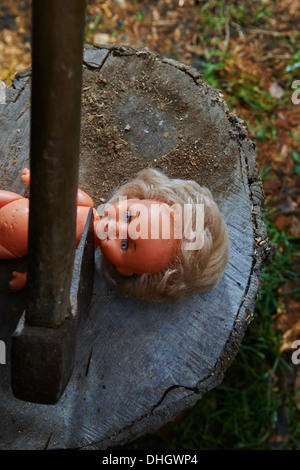 Esecuzione - omicidio del bambino di plastica giocattolo baby doll con un'ascia Foto Stock