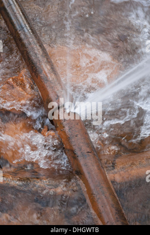 Burst tubazione acqua ghisa nel flusso Foto Stock