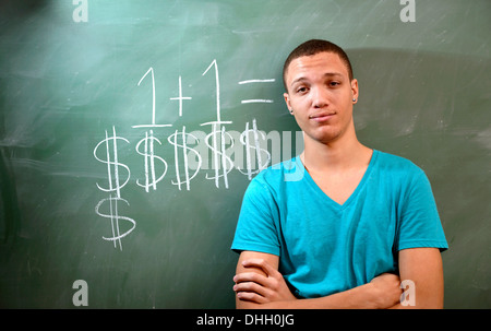 Un giovane uomo su un campus universitario con una lavagna e un commento circa il costo dell'istruzione. Foto Stock