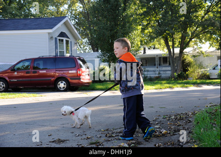 Little Boy cercando prima di attraversare la strada con il cane Foto Stock