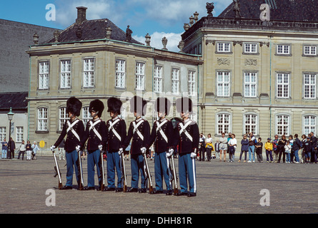 Le protezioni in uniforme con copricapo BEARSKIN presso il Palazzo di Amalienborg Copenhagen DANIMARCA Foto Stock