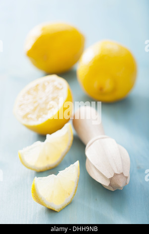 Il limone e strizzatore su sfondo blu Foto Stock
