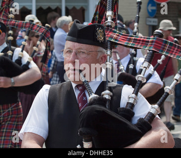 Scottish bagpiper marciando in strada Foto Stock