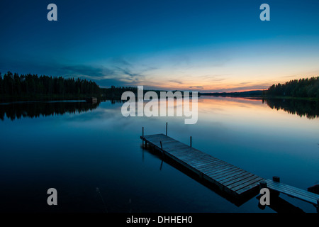 Il lago e il molo in legno all'alba, Skelleftea, Lapponia, Svezia Foto Stock