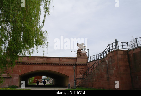 Cielo grigio visualizzare red arco di pietra arenaria scolpita con attraversamento di Griffin Ludwig Erhard Ufer sentiero, sul fiume Spree, Berlino, Germania Foto Stock