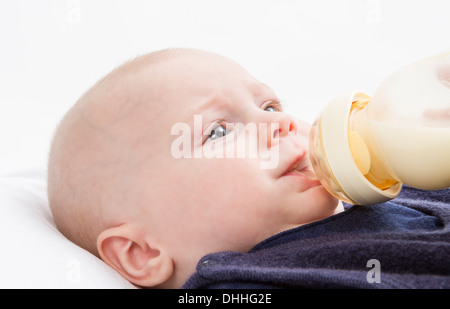 Nursling con bottiglia di latte in sfondo luminoso. studio shot Foto Stock