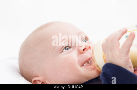 Nursling con bottiglia di latte in sfondo luminoso. studio shot Foto Stock