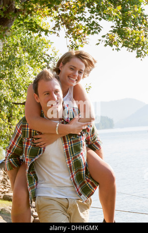 Giovane uomo che donna piggy back Foto Stock