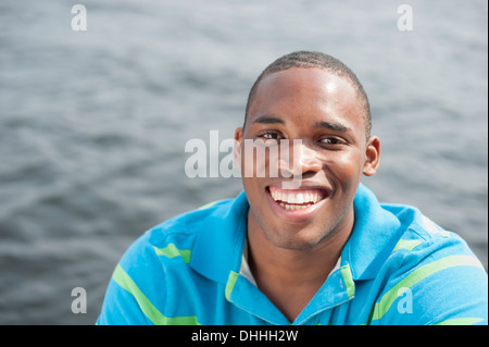 Ritratto di giovane uomo che indossa blue Polo shirt, sorridente Foto Stock