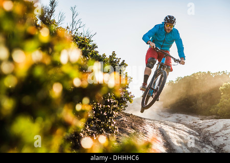 Giovane uomo mountain bike su roccia, Monterey, California, Stati Uniti d'America Foto Stock