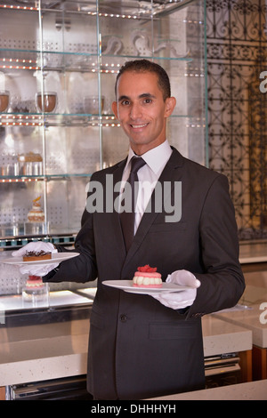 Cameriere che serve pasticceria presso il Royal Mansour Hotel, Marrakech, Marrakesh-Tensift-El Haouz regione, Marocco Foto Stock