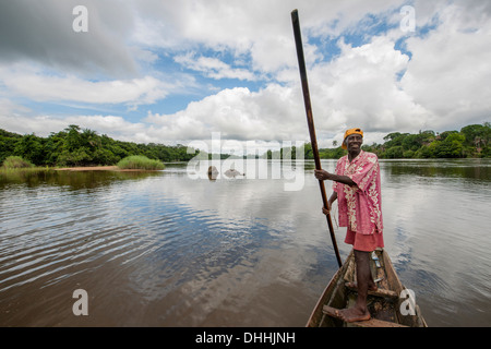 Uomo volante una piroga sul fiume Moa a Tiwai Island Wildlife Sanctuary, Tiwai Island, sud della provincia, Sierra Leone Foto Stock