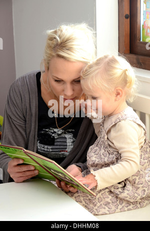 Madre la lettura di un libro con la sua piccola figlia, Svezia Foto Stock