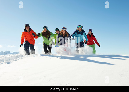 Amici in esecuzione nella neve, Kuhtai, Austria Foto Stock