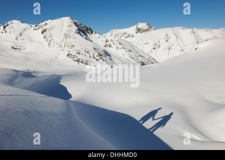 Ombra del giovane tenendo le mani nella neve, Kuhtai, Austria Foto Stock