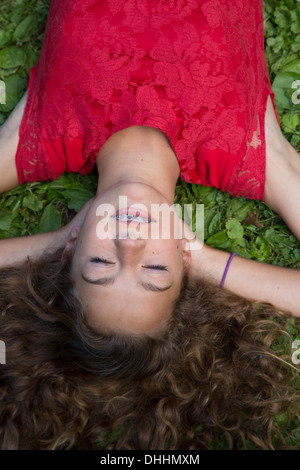 Close up della ragazza adolescente sdraiati sull'erba Foto Stock