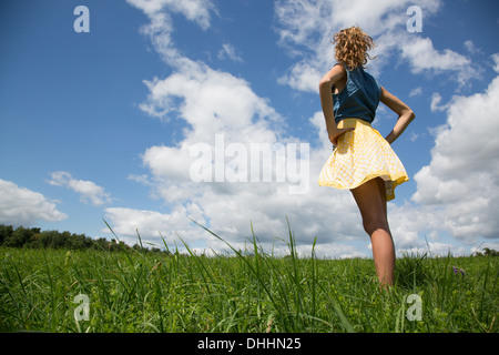 Ragazza adolescente in piedi con le mani sui fianchi in campo Foto Stock