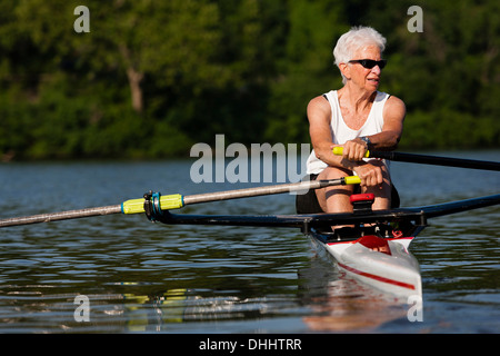 Senior donna barca a remi in barca a remi Foto Stock