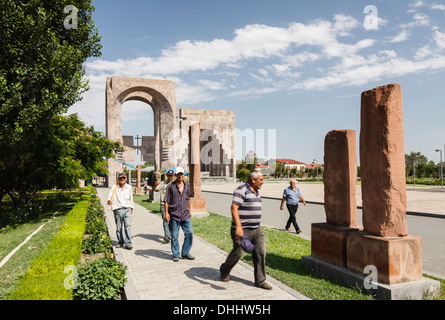 Uomini armeno accanto ad antichi khatchkars, la Porta di San Gregorio e open-air altare del 2001 visita papale monumento. Echmiadzin Foto Stock