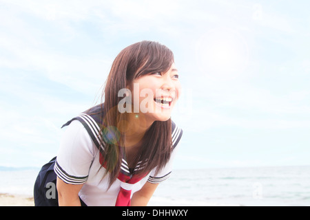 Giovane donna inclinato in avanti di ridere Foto Stock