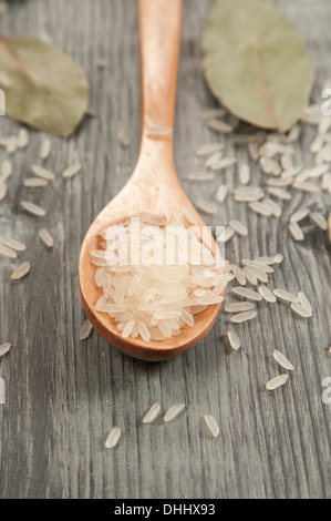 Il riso in un cucchiaio di legno e foglie di alloro Foto Stock