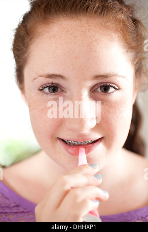 Ragazza applicando lip gloss Foto Stock