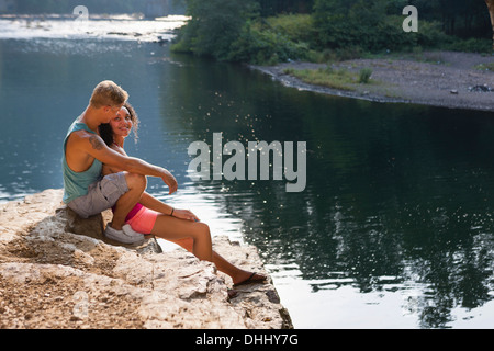 Coppia giovane seduto sulla sporgenza di roccia, Amburgo, Pennsylvania, STATI UNITI D'AMERICA Foto Stock