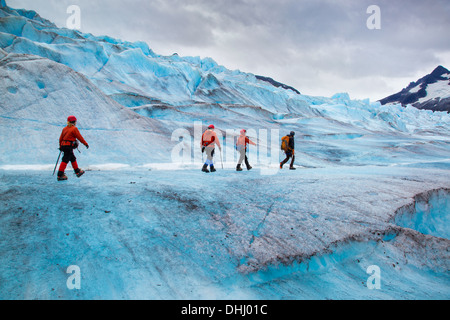 Quattro persone che camminano su Mendenhall Glacier, Alaska, STATI UNITI D'AMERICA Foto Stock