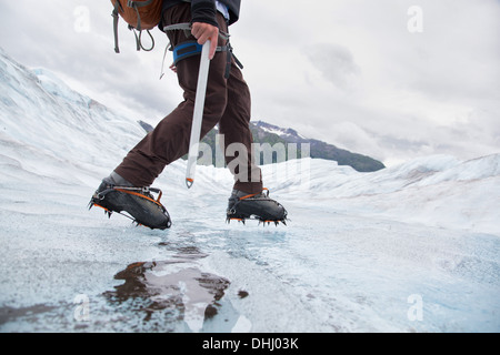 Giovane uomo che cammina su Mendenhall Glacier, Alaska, STATI UNITI D'AMERICA Foto Stock