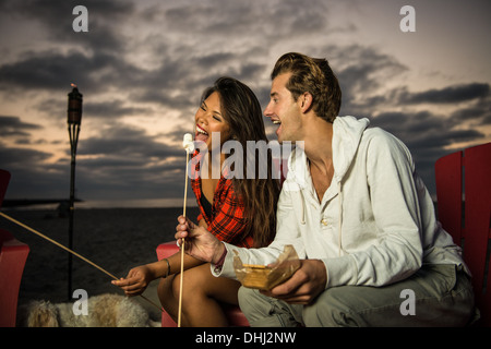 Coppia giovane la tostatura marshmallow nel falò, San Diego, California, Stati Uniti d'America Foto Stock