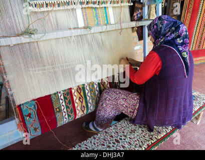 Donna tessitura di un tappeto turco o rug a mano, Cappadocia, Turchia Foto Stock